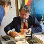 Juan Inurria firmando ejemplar